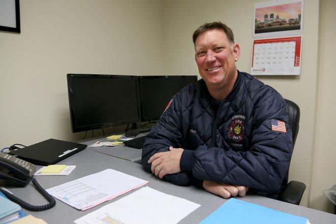 Jeff Denton smiling at a desk. 